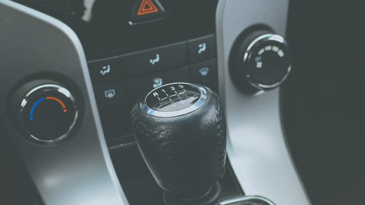 Detailed view of a manual gear shift knob and car console interior.